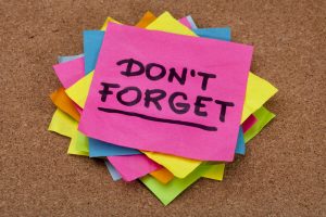 do not forget reminder - a stack of colorful sticky notes on cork bulletin board