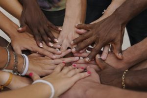 Many hands together: group of diverse people joining hands